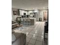 Inviting open-concept kitchen and living area with white tile flooring and ample seating at 1704 Osceola Park Dr, Kissimmee, FL 34741