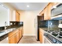 Compact kitchen with light wood cabinetry, dark countertops, and stainless steel appliances at 2053 Dixie Belle Dr # 2053C, Orlando, FL 32812