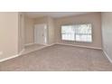 Bright living room with large window and neutral carpeting at 1205 Longville Cir, Tavares, FL 32778