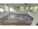 Bright sunroom features new wood-look flooring and multiple windows at 26221 Se 159Th Ln, Umatilla, FL 32784