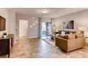Spacious living room with tile floors, brown sofa, and access to a patio at 6098 Galloping Dr, Apopka, FL 32712