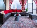 Relaxing screened-in patio with wicker furniture and red accents at 8933 Amelia Downs Trl, Kissimmee, FL 34747
