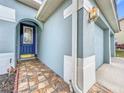 Front entrance with blue door, tile walkway, and garage at 944 Torrey Pine Dr, Winter Springs, FL 32708