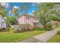 Two-story pink house with white accents situated on a tree-lined street at 1217 Magnolia Ave, Sanford, FL 32771