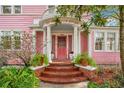 Brick steps leading to a beautiful pink front door with a columned portico at 1217 Magnolia Ave, Sanford, FL 32771