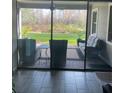 View of the backyard through sliding glass doors from the living area, showing patio furniture and landscaping at 13007 Bromborough Dr, Orlando, FL 32832