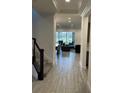 Welcoming entryway with tiled flooring, a staircase with black railing, and a view of the living area at 13007 Bromborough Dr, Orlando, FL 32832