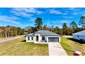 New construction home with a gray roof and driveway at 14949 Sw 65Th Avenue Rd, Ocala, FL 34473