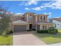 Stunning two-story home with a paver driveway and lush landscaping at 2731 Flintlock Ave, Clermont, FL 34711