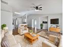 Bright living room with hardwood floors, cream sofas, and a mid-century modern coffee table at 66 Fir Dr, Ocala, FL 34472