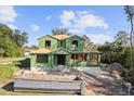 Two-story house under construction with green building wrap, visible framing and a dumpster at 1309 Errol Green Ct, Apopka, FL 32712