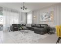 Spacious living room with a large sectional sofa, stylish decor, and ample natural light at 1671 Kona Ln, Davenport, FL 33897