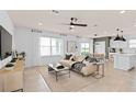 Open living space with beige sofa, large TV, and access to kitchen at 3645 Cambridge Brook Dr, Davenport, FL 33837