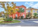 Two-story coral home with palm trees and landscaped yard at 4756 Ormond Beach Way, Kissimmee, FL 34746