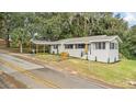Renovated home with carport, landscaping, and double yellow lines on street at 507 Orange Ave, Ocoee, FL 34761