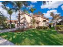 Two-story house with light peach walls, red tile roof, and palm trees at 11313 Via Andiamo, Windermere, FL 34786