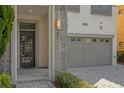 Front entry with modern door and attached garage at 1239 Radiant St, Reunion, FL 34747
