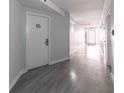 Clean hallway with light gray walls and wood-look flooring at 151 E Washington St # 201, Orlando, FL 32801