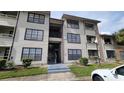 Condo building entrance with stairs and landscaping at 4601 Cason Cove Dr # 214, Orlando, FL 32811