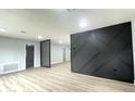 Living room with gray walls, wood-look floors, and a modern black accent wall at 1625 Normandy Way, Leesburg, FL 34748