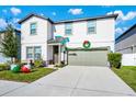 Two-story house with green garage door and a Marlins flag at 2362 Lancashire St, Davenport, FL 33896