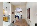 Dining area with wooden table, white chairs, and view of the kitchen and living room at 605 Rum Run # 605, Davenport, FL 33837