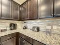 Kitchen counter with granite countertop, small appliances, and a stylish tile backsplash at 826 Paradise Dr, Davenport, FL 33897
