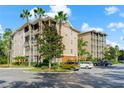 View of the building's exterior, showcasing its design, landscaping, and parking area at 9051 Treasure Trove Ln # 102, Kissimmee, FL 34747
