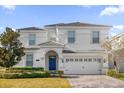 Two-story home with blue front door, attached garage, and landscaped yard at 1528 Mulligan Blvd, Davenport, FL 33896