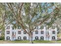 View of a row of townhouses with white exteriors, black shutters, and red tiled roofs at 234 N Glenwood Ave # 4, Orlando, FL 32803