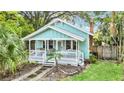 Quaint light blue house with a white porch and lush green lawn at 1550 Indiana Ave, Winter Park, FL 32789