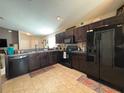 Modern kitchen with dark wood cabinets and black appliances at 2464 Deer Creek Blvd, St Cloud, FL 34772