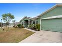Paved driveway leading to a green one-story home with attached garage at 5761 Woodruff Way, Lakeland, FL 33812