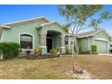 One-story home with a green exterior, landscaped yard, and decorative statues at 5761 Woodruff Way, Lakeland, FL 33812