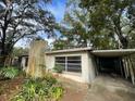 Exterior view of a home with a carport, chimney, and some landscaping at 826 Rosalia Dr, Sanford, FL 32771