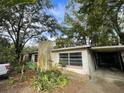 Exterior view of a single-story home with a carport, chimney, and landscaping at 826 Rosalia Dr, Sanford, FL 32771