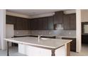 Modern kitchen with dark wood cabinets, light countertops, and stainless steel appliances at 14568 Crestavista Ave, Clermont, FL 34714