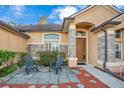 Inviting front entry with stone accents and two black adirondack chairs at 1942 Willow Wood Dr, Kissimmee, FL 34746