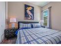 Inviting bedroom with blue and white plaid bedding and modern decor at 244 Villa Domani Cir, Davenport, FL 33896