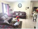 Bright living room with a floral sofa and matching chairs at 6440 Livewood Oaks Dr, Orlando, FL 32818