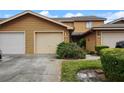 Tan townhome with attached garage and landscaping at 707 Carpenters Way # 45, Lakeland, FL 33809