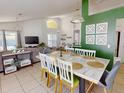 Open-concept dining area adjacent to the living room, with a marble dining table and green accent wall at 1017 Lake Berkley Dr, Kissimmee, FL 34746