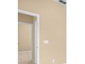 Hallway with neutral-toned walls and tiled flooring leading to other rooms at 10421 Andover Point Cir, Orlando, FL 32825