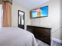 Bedroom featuring a wall-mounted TV, dresser, and comfortable bed at 3100 Parkway Blvd # 110, Kissimmee, FL 34747