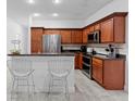 Modern kitchen with stainless steel appliances, wood cabinetry, and dark countertops at 686 Cotulla Dr, Kissimmee, FL 34758