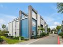Modern townhome exterior with blue and gray siding, balconies, and a driveway at 7770 Sandy Ridge Dr # 114, Reunion, FL 34747