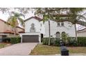 Two-story house with white walls, brown garage door, and a red tile roof at 11410 Rapallo Ln, Windermere, FL 34786