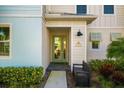 Front entryway with mint green door, bench, and lush landscaping at 2956 Caribbean Soul Dr, Kissimmee, FL 34747