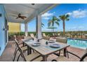 Covered patio with dining table and chairs overlooking the pool at 3056 Parrot Head Pl, Kissimmee, FL 34747