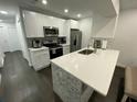 Modern kitchen featuring white shaker cabinets, stainless steel appliances, and a large island at 8711 Rockingham Ter # D, Kissimmee, FL 34747